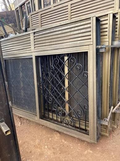 Fabricated steel window with a security grille and louvered panel