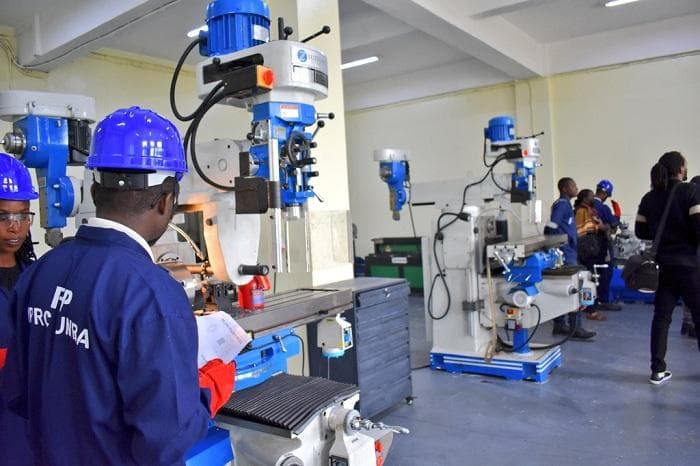Technicians working at milling machines in a technical workshop