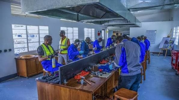 Technicians learning practical skills at a workshop bench